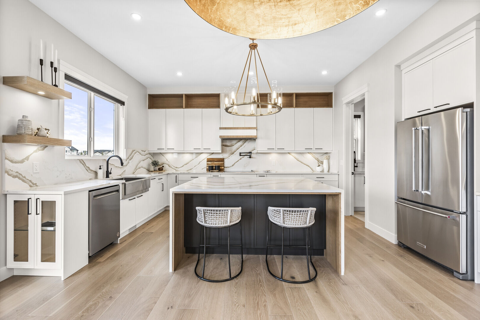 Modern luxury kitchen with stools at island, marble and wood counter tops